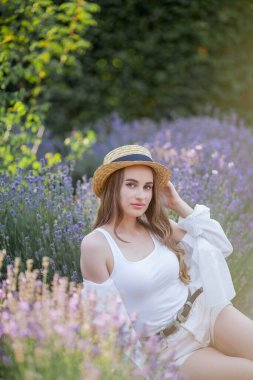 Gün batımında güzel genç bir kadın. Lavanta çiçekli güzel bir kadının portresi..