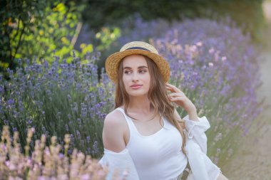 Gün batımında güzel genç bir kadın. Lavanta çiçekli güzel bir kadının portresi..