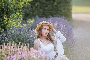 Gün batımında güzel genç bir kadın. Lavanta çiçekli güzel bir kadının portresi..