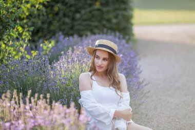 Gün batımında güzel genç bir kadın. Lavanta çiçekli güzel bir kadının portresi..