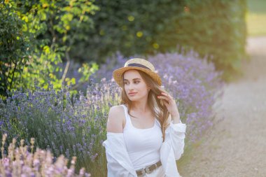 Gün batımında güzel genç bir kadın. Lavanta çiçekli güzel bir kadının portresi..