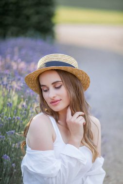 Gün batımında güzel genç bir kadın. Lavanta çiçekli güzel bir kadının portresi..