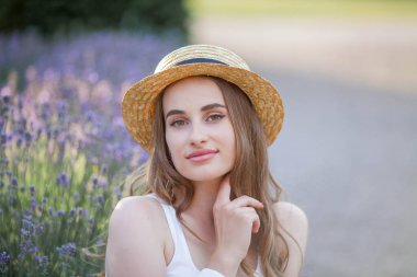 Gün batımında güzel genç bir kadın. Lavanta çiçekli güzel bir kadının portresi..