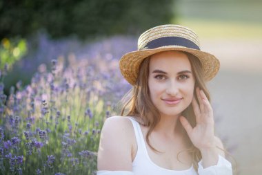 Gün batımında güzel genç bir kadın. Lavanta çiçekli güzel bir kadının portresi..