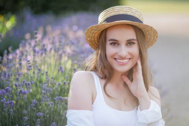 Gün batımında güzel genç bir kadın. Lavanta çiçekli güzel bir kadının portresi..