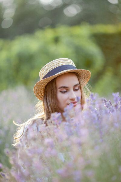 Beautiful young woman in the sunset light. Portrait of a beautiful woman in blooming lavender.