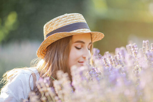 Beautiful young woman in the sunset light. Portrait of a beautiful woman in blooming lavender.