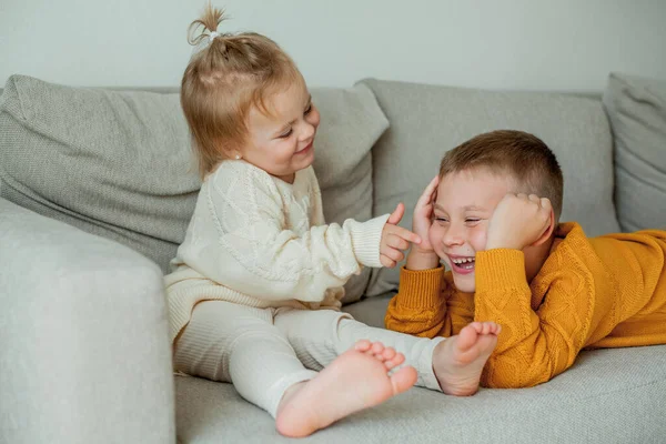 居心地の良いニットのセーターを着た弟と妹が自宅で遊んでいます かわいい弟と妹の肖像画 — ストック写真
