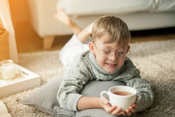 Vacker Liten Pojke Stickad Tröja Läser Vid Fönstret Med Mugg — Stockfoto