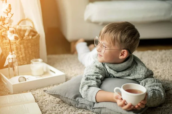 Vacker Liten Pojke Stickad Tröja Läser Vid Fönstret Med Mugg — Stockfoto