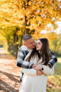 Sonbahar sarı parkında birbirine aşık genç bir çiftin portresi..