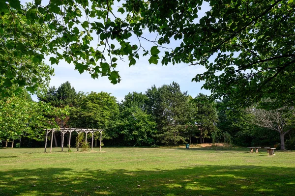 College Green in Bromley, Kent.  This open space near the center of Bromley has grass areas, flowers and trees.  Photo shows seats and a pergola. The Borough of Bromley is in Greater London.