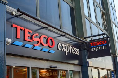 Bromley (Büyük Londra), Kent, İngiltere. Bromley High Caddesi 'ndeki Tesco Express mağazasında. Tesco Express adını ve amblemini dükkan girişinde kırık Tesco Express tabelasıyla gösterir.