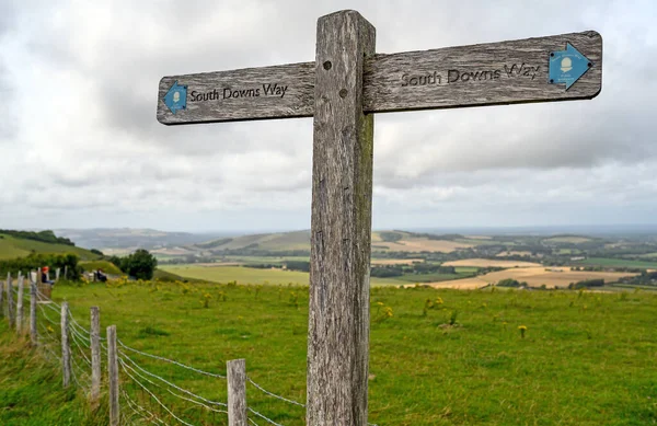 South Downs National Park, Sussex, UK near Firle Beacon. A signpost shows the route of the South Downs Way with views over the Weald. The South Downs Way is a national trail popular with walkers.