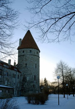 Tallinn, Estonya şehir duvarında bir savunma kulesi. Alçak güneşin uzun gölgeler bıraktığı kış sahnesi. Şehir duvarı ortaçağ Tallinn Eski Kasabasını koruyor..
