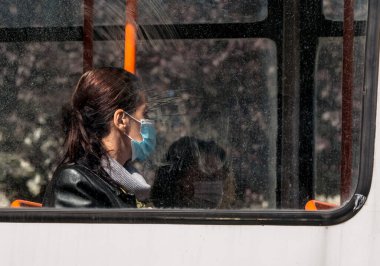 Bükreş / Romanya - 05.16.2020: Bükreş 'te halk otobüsü veya tramvayda yüz maskesi takan insanlar toplumsal uzaklık kuralına saygı gösteriyorlar.