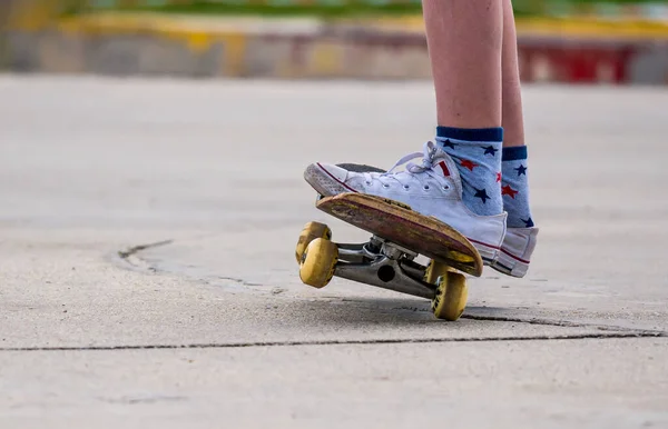 Close up with a young man's feet on a skateboard.