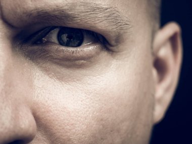 Yarım yüz, kameraya bakan bir adamın detaylı portresi..