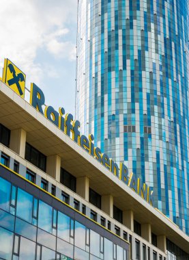 Bükreş / Romanya - 07.18.2020: Bükreş 'te arka planda bir skycraper bulunan bir ofis binasının Raiffeisen banka logosu.