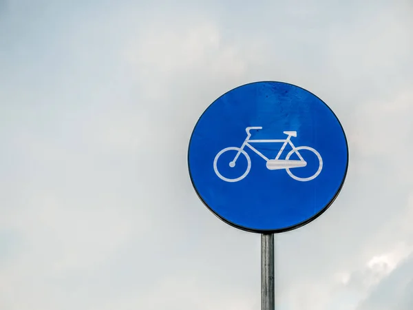 Street or road sign with a bicycle. Bicycle sign with cloudy sky as background.