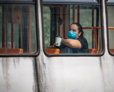 Bükreş / Romanya - 07.25.2020: Bükreş 'te kadın yüz maskesi takıyor ve halk otobüsü veya tramvayda toplumsal uzaklık kuralına riayet ediyor.