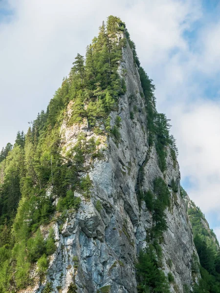 Mavi bulutlu gökyüzüne karşı keskin piramit şekilli kaya. Romanya 'nın Bucegi Montains kentindeki kayalık zirvede ayrıntılar