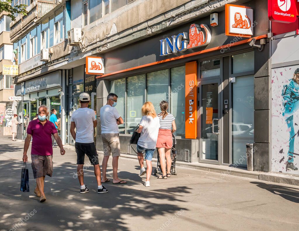 Bucuresti/Romania - 08.18.2020: People waiting in line in front of a ING Bank branch respecting the social distancing to prevent and stop the coronavirus outbreak. ING bank in Bucharest, Iuliu Maniu branch