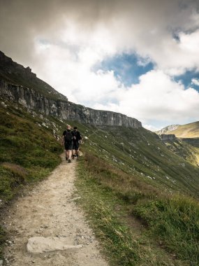 Yürüyüşçüler Bucegi Dağları 'nda dramatik bir gökyüzüne karşı yoldalar..