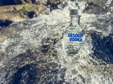 Brasov / Romanya - 08.28.2020: Bir dağ deresinin sularında bir şişe Absolut Votka