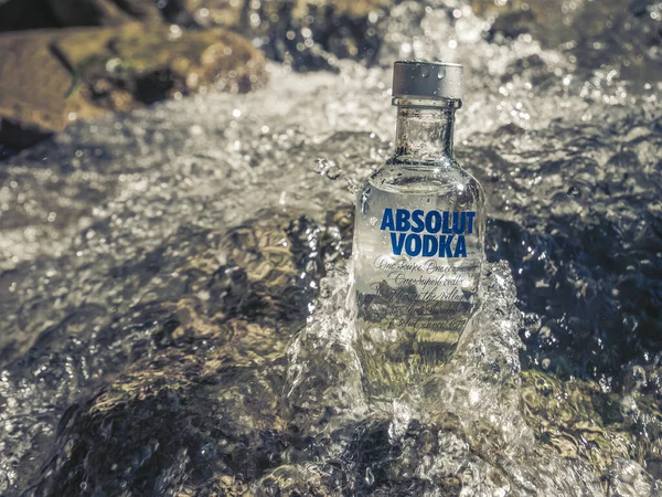 Brasov / Romanya - 08.28.2020: Bir dağ deresinin sularında bir şişe Absolut Votka