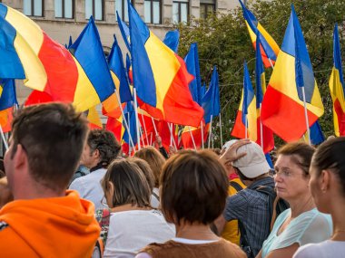 Bükreş / Romanya - 09.19.2020: Ellerinde Romen bayrakları olan pek çok kişi okullarda yüz maskesi takmayı protesto ediyor.