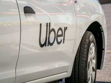 Bükreş / Romanya - 09.05.2020: Beyaz boyalı bir arabada Uber logosu yazılı. Trafikte Uber araba.