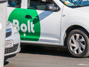 Bükreş / Romanya 09.05.2020: Beyaz bir arabanın üzerine basılmış Estonya ulaşım platformu Bolt 'un logosu. Sürücü istemciyi bekliyor.