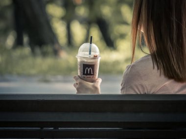 Bükreş / Romanya - 09.19.2020: McDonalds 'tan bir milkshake taşıyan bir kız.