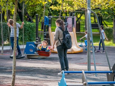 Bükreş / Romanya - 09.19.2020: Parkta annelerinin gözetiminde oynayan çocuklar.