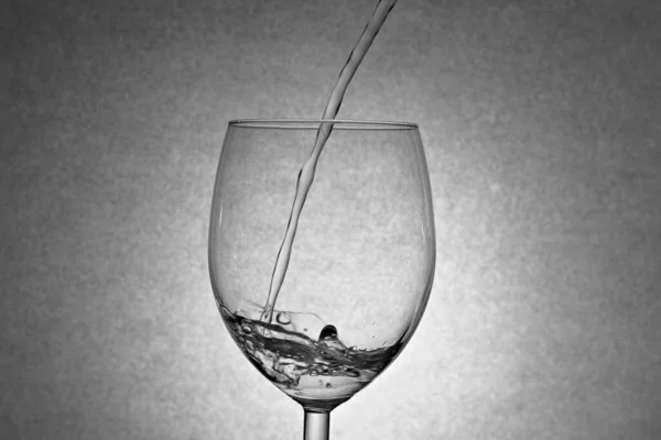 Acqua gocciolante nel bicchiere di vino. — Foto Stock