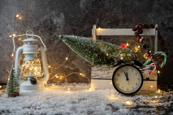 Foto von Laterne, Uhr, Schachtel mit Weihnachtsbaum, brennender Kranz auf schwarzem Tisch — Stockfoto