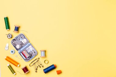 Kompozisyon konuları ve dikiş aksesuarları - makas, santimetre, sarı zemin üzerine iğne.