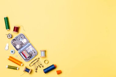 Kompozisyon konuları ve dikiş aksesuarları - makas, santimetre, sarı zemin üzerine iğne.