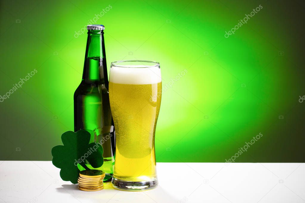 Buttle and glass of fresh cold beer on a white table. Concept for St. Patricks day.