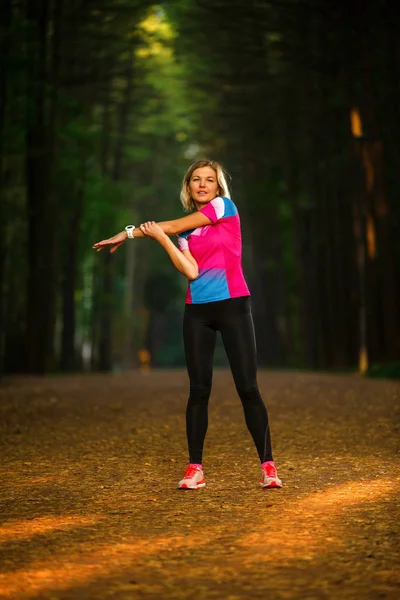 Bild eines jungen Mädchens dehnt sich im Sommerpark — Stockfoto