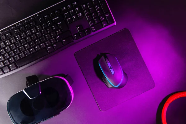 Visão superior um equipamento de jogo, mouse, teclado, joystick, fone de ouvido, fone de ouvido VR no fundo da mesa preta . — Fotografia de Stock