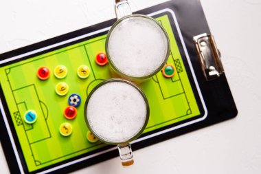 Resminin üst kısmında iki bardak köpüklü bira, Masa futbolu