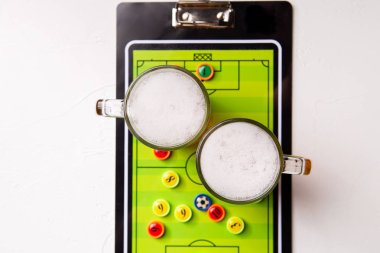 Resminin üst kısmında iki bardak köpüklü bira, Masa futbolu