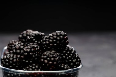 Blackberry boş siyah arka plan üzerine plastik kap içinde görüntü.