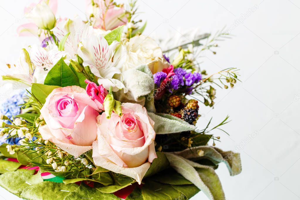 Photo of romantic bouquet of pink roses, lilies, green leaves on white background