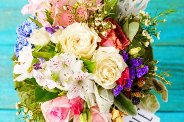 Yukarıdan fotoğrafı romantik buket pembe güller, zambaklar, yeşil yaprakları.