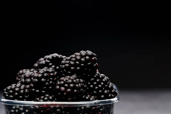 Foto de mora en contenedor de plástico sobre fondo negro vacío . — Foto de Stock