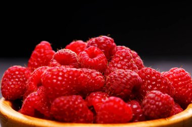 Ahududu siyah arka plan üzerine ahşap Kupası fotoğrafı