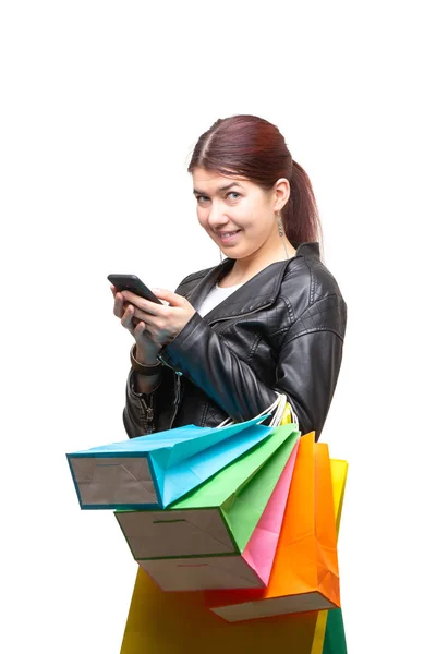 Счастливая молодая женщина с сумками и телефоном — стоковое фото